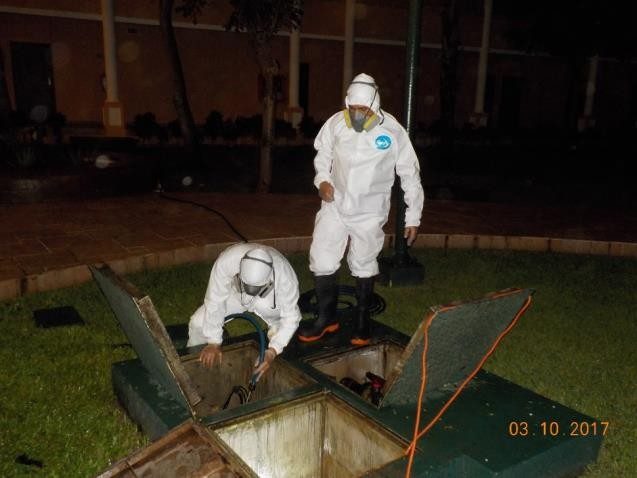 Técnicos con traje de protección abriendo el registro de un cárcamo